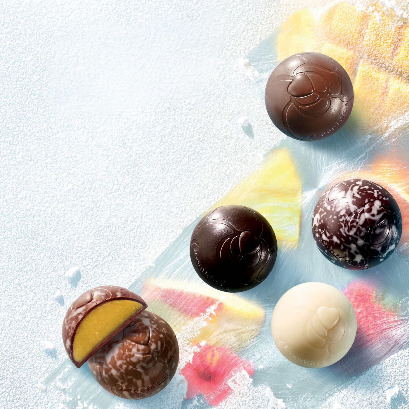Assorted frozettes chocolates on an icy white surface