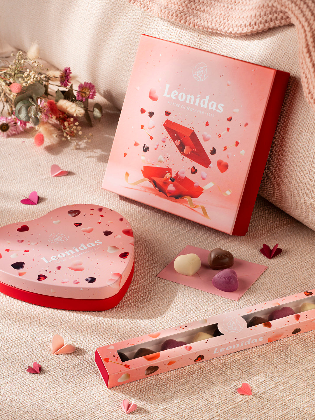 Leonidas chocolate packaging with heart-shaped box and Valentine's Day-themed design on a soft surface.